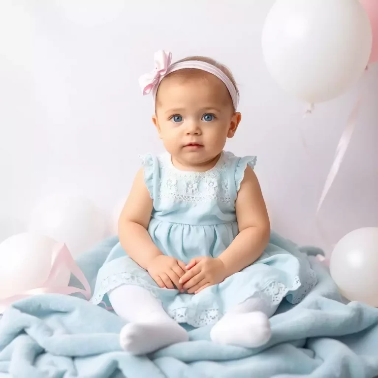Bebê com vestido bordado, refletindo elegância nas combinações com Quitéria.